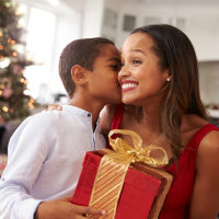 Son kissing mom with Christmas present