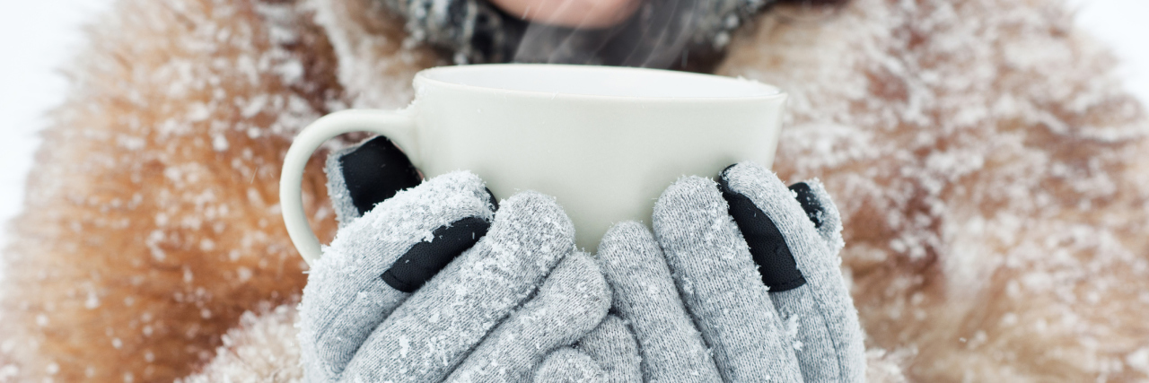 woman holding a mug outside in the snow