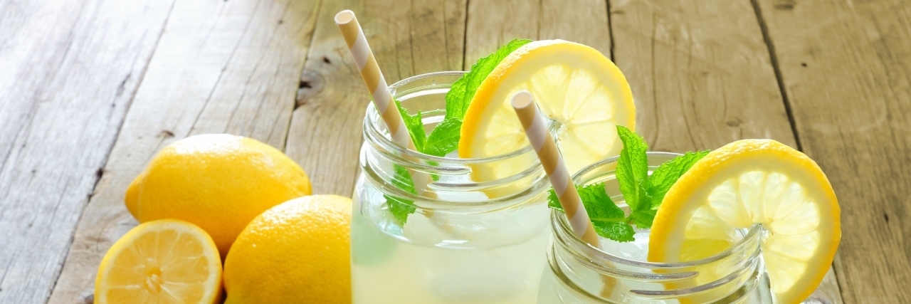 Using Humor to Explain the Challenges of Cerebral Palsy Two mason jar glasses of homemade lemonade on a rustic wooden table.