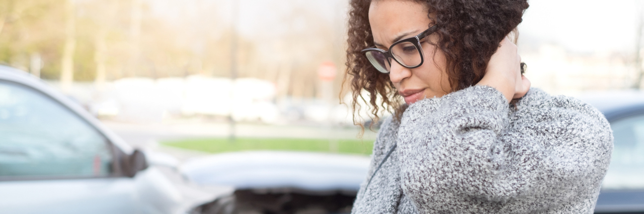 What to Do in a Moment of Crisis If You Have Chronic Pain woman holding her head in pain after a car collision