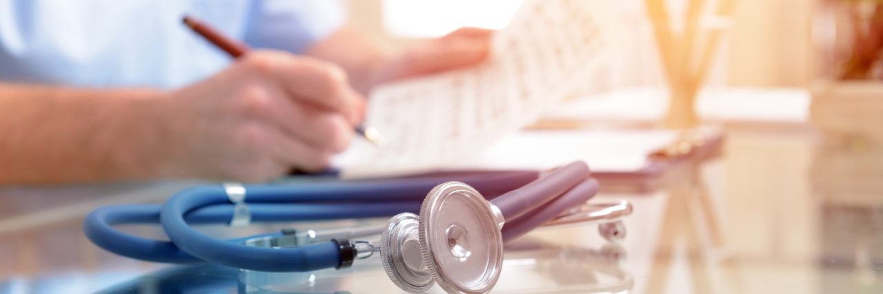 Spinal Muscular Atrophy and Chronic Pain Close up of stethoscope and doctor.