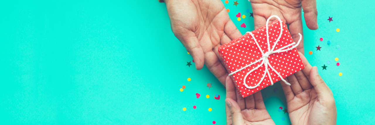 Is It OK to Give Your Therapist a Gift for the Holidays? Male gives a gift to female with green background