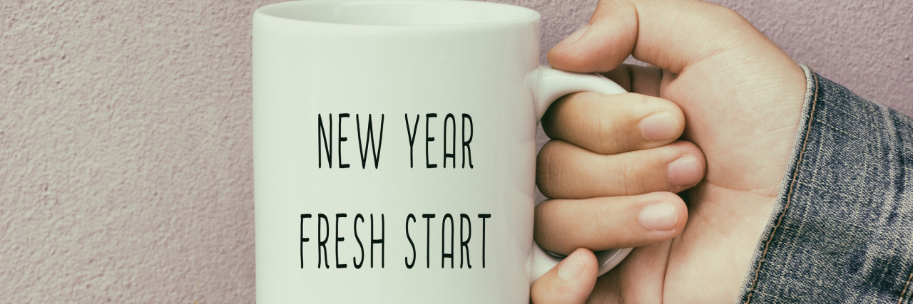 10 Things I Learned About Chronic and Mental Illness in 2018 hand holding coffee mug that says new year fresh start