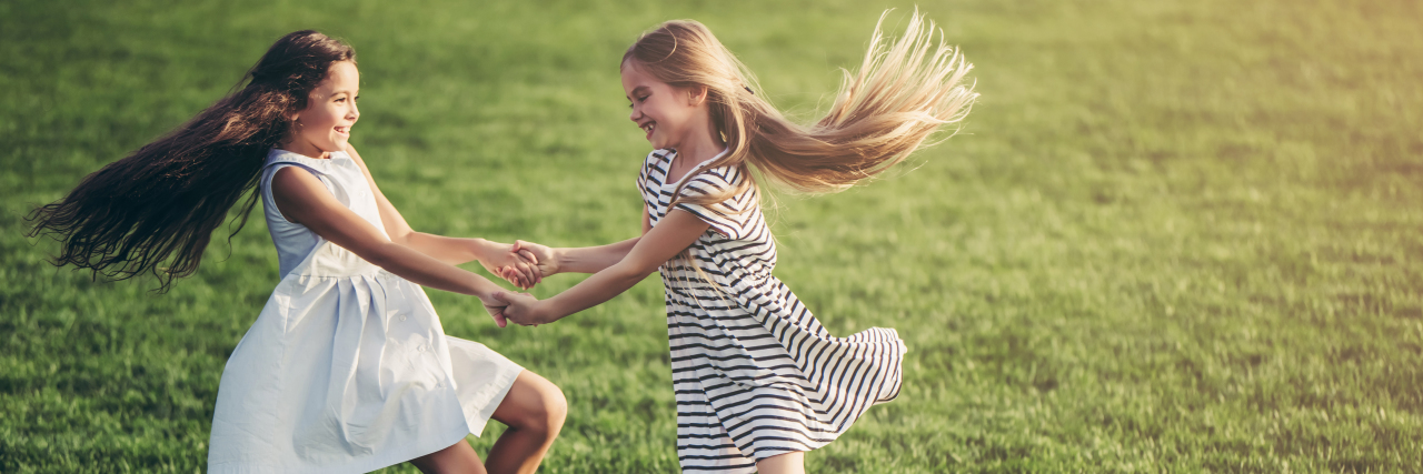 Discovering My Autism as an Adult Two girls playing in a grassy field.