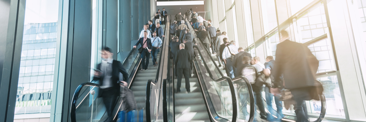 Disability Is a Societal Issue Busy escalator in airport.