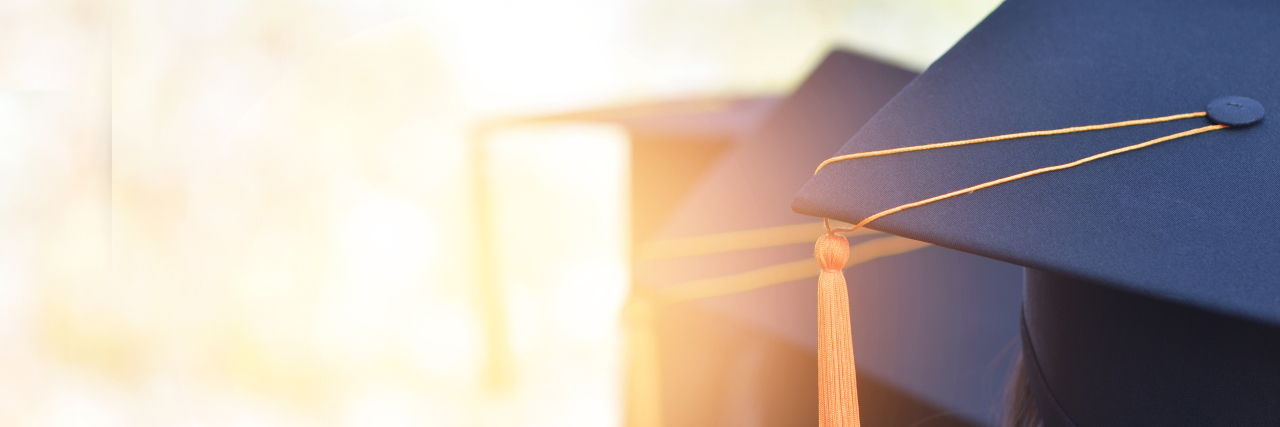 Studying for a Ph.D. as a Blind Student University graduates wearing a yellow tasseled cap, seen from the back.