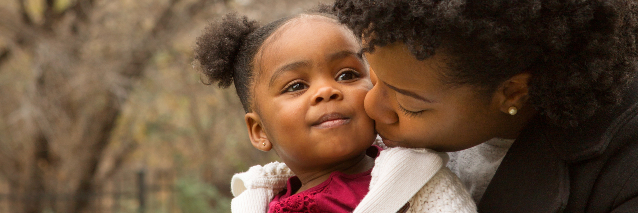 mother and young daughter on park bench