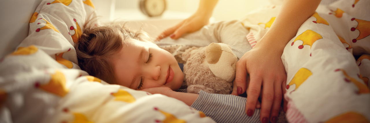 Mother waking up sleeping daughter.