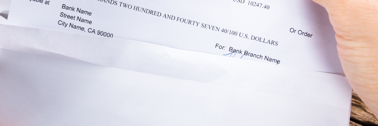 Being on Government Assistance as a Man With Autism Man opening envelope with check.