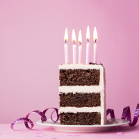Chocolate birthday cake with pink frosting and candles