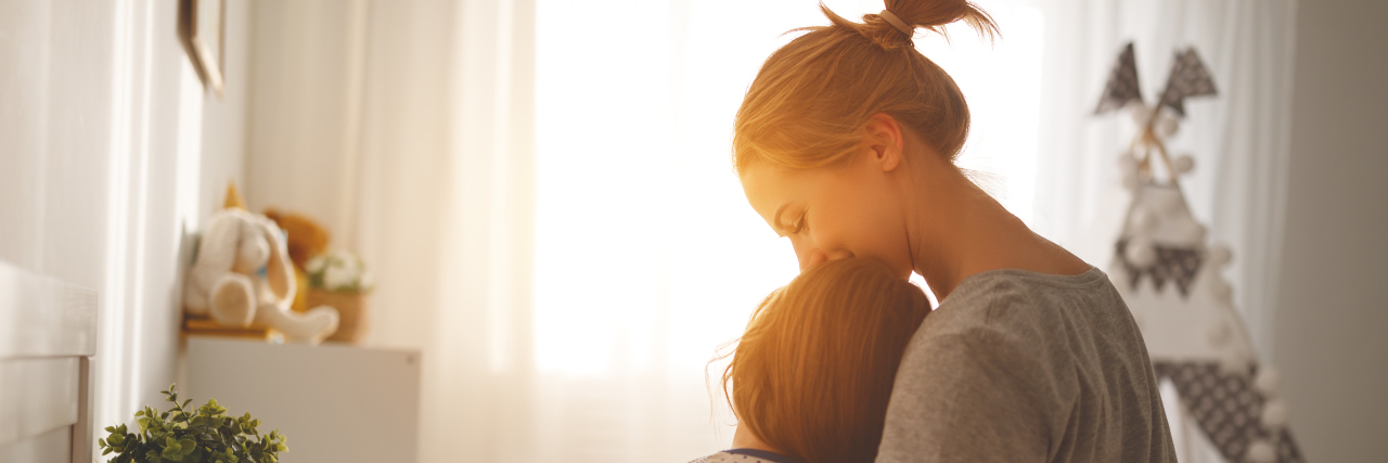 Mother sitting by her child in bed