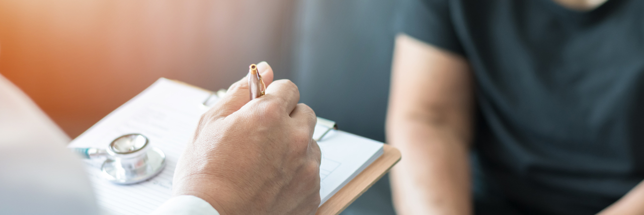 When a Doctor Doubted My Chronic Pain Doctor making notes while examining patient.