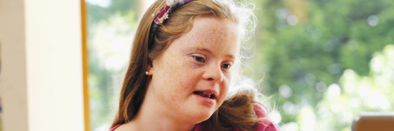 Teenage girl with Down syndrome on her laptop