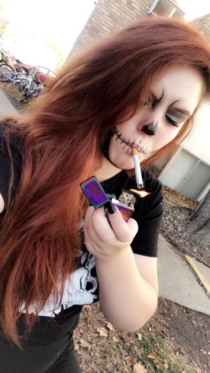 woman with skeleton face paint smoking a cigarette