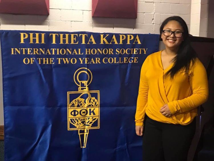 woman standing in front of school banner