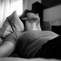 black and white photo of man sleeping on the couch