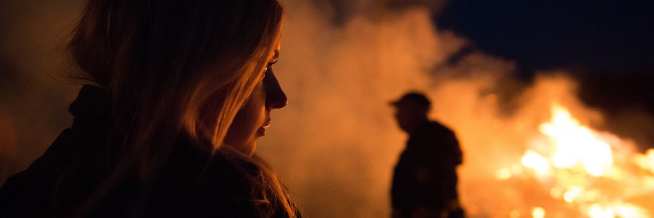 How to Cope With Suppressing Feelings and Emotions woman silhouetted and illuminated by flames looking at fire