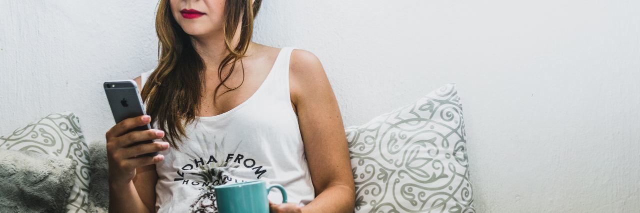 How to Get Out of Bed When Depression Stops You woman looking at phone and drinking coffee while sitting in bed
