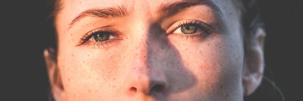 close up photo of a woman with freckles in the sunlight