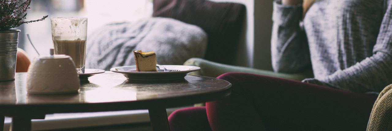 Self-Care Promises You Should Make to Yourself woman in coffee shop reading a book and thinking