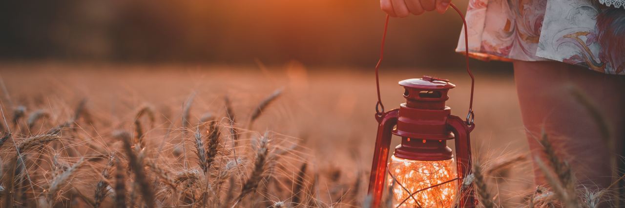 My Depression Will Have Meaning woman holding lamp in field of wheat at sunset