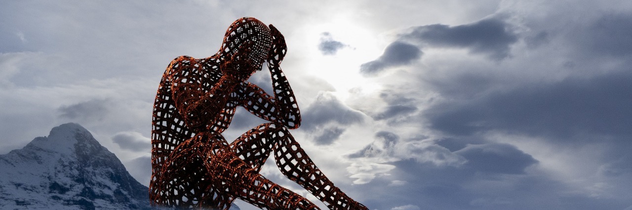 Losing and Finding Yourself in Chronic Pain outline of a person sitting alone in the mountains and clouds