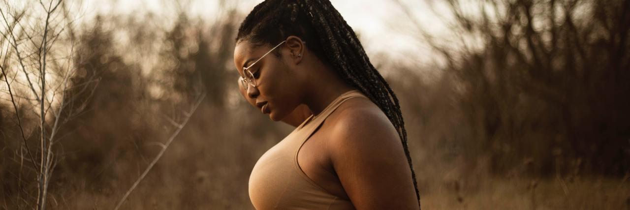 black woman in countryside wearing glasses in profile