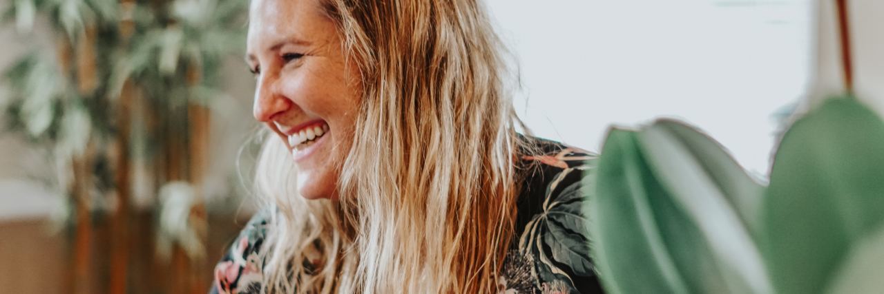 Is It Healthy to Use Humor to Cope With Mental Illness? photo of blonde woman wearing floral dress and laughing