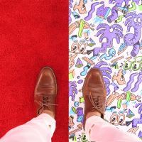 photo of person's standing looking down at shoes either side of floor with plain flooring on one side and vibrant on the other