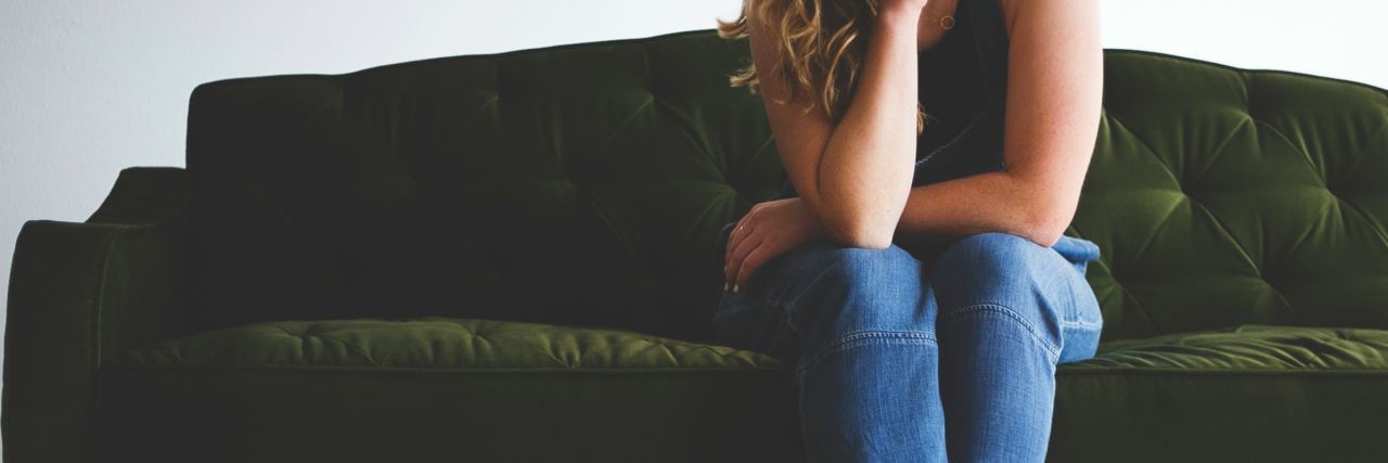 What Mood Cycling Feels Like woman on green sofa resting head on hand