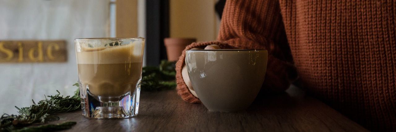 What I Wish I’d Known as a Kid With Anorexia Nervosa close up of woman sitting at table in sweater holding mug of coffee