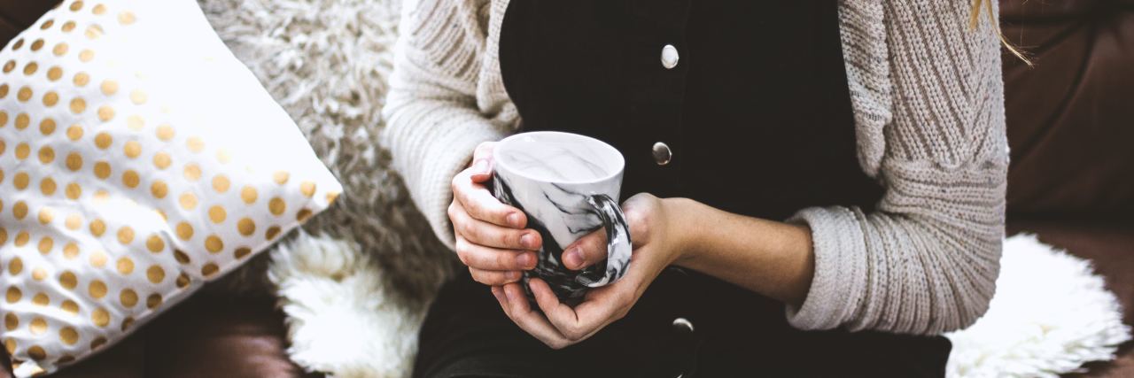 What Mental Health Professionals Need to Know About Their Power woman sitting on leather couch holding mug of tea or coffee