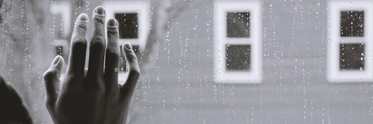 Woman's hand against window.