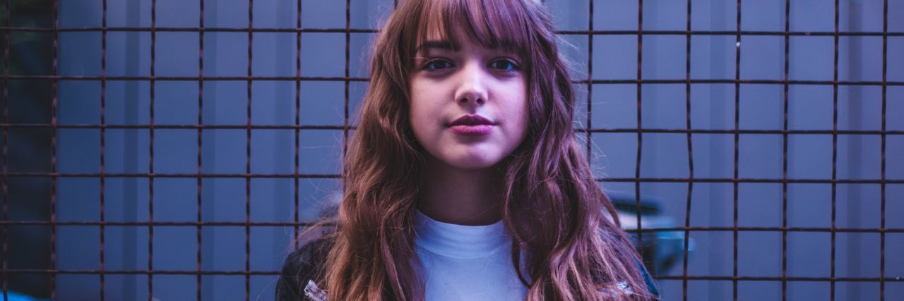 When Doctors Assume What's Wrong Based on Mental Health Record young woman standing in front of fence in sportswear