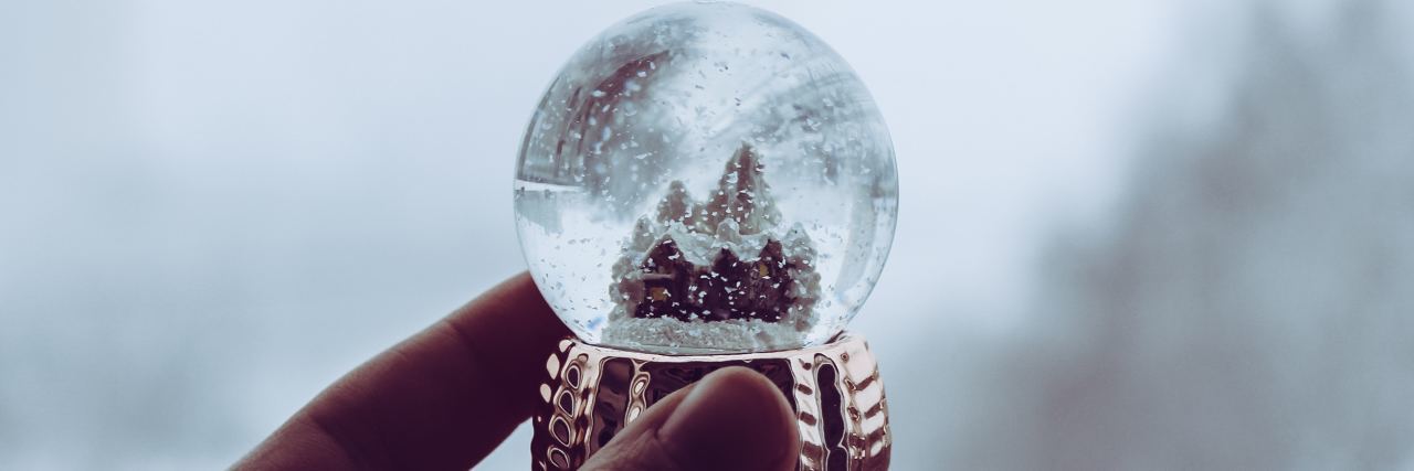 How to Cope With BPD During the Holiday Season person holding snow globe against misty background
