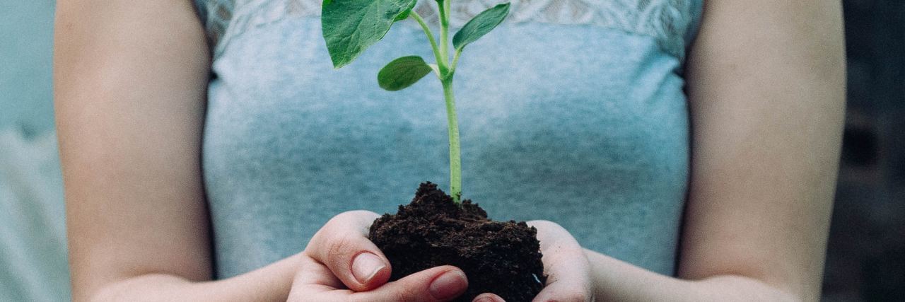 Why 'Alternatives' to Suicide Help Me When I Am Struggling woman holding shoot of plant in soil