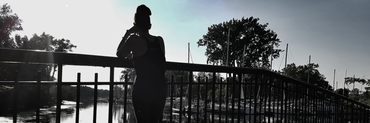Read This If You're Going Through a Tough Time Right Now woman standing on boardwalk silhouetted in sunlight