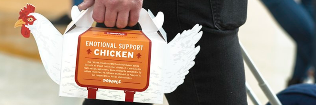 Popeyes chicken-shaped box with a man holding the handles at the top of the chicken.