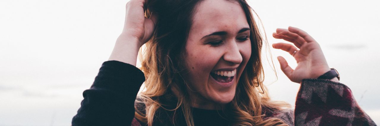 Summer In Eating Disorder and Addiction Recovery woman smiling and laughing on beach during summer