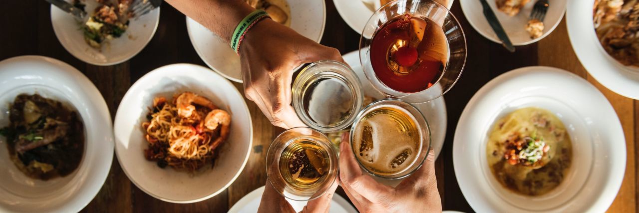 Tips for Eating at Holiday Parties When You Have Dietary Restrictions people clinking glasses over a dinner table