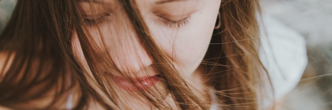 How to Practice Self-Care When Overwhelmed With Depression and Anxiety close up of young woman with eyes closed and slight smile