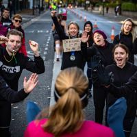 woman finishing marathon with people waiting for her
