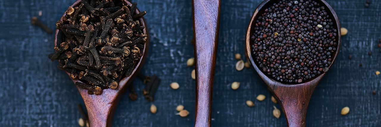 How to Explain Spoon Theory to Friends When Too Tired to Be Social photo of wooden spoons containing seeds or grains on dark background
