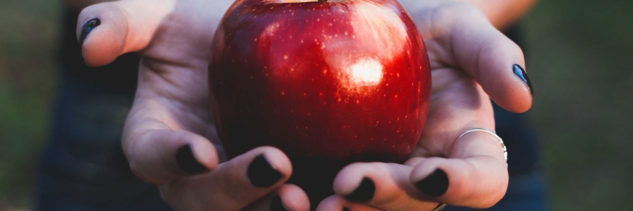 The Unexpected Benefit of Mindfulness in a Busy Location person holding out red apple in hands