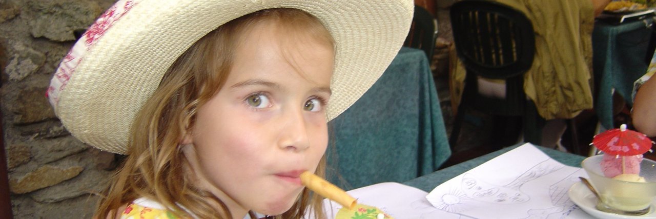 Why School Hearing Loss Screenings Are Important Julia at age 5, wearing a big hat and eating ice cream.