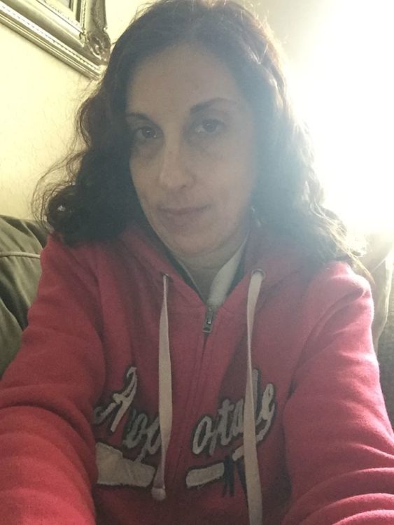 woman wearing a pink hoodie and taking a selfie