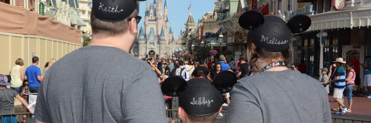 When I Left My Job After My Myasthenia Gravis Diagnosis dad, mom and son with arms around each other wearing mickey ears, facing disneyland