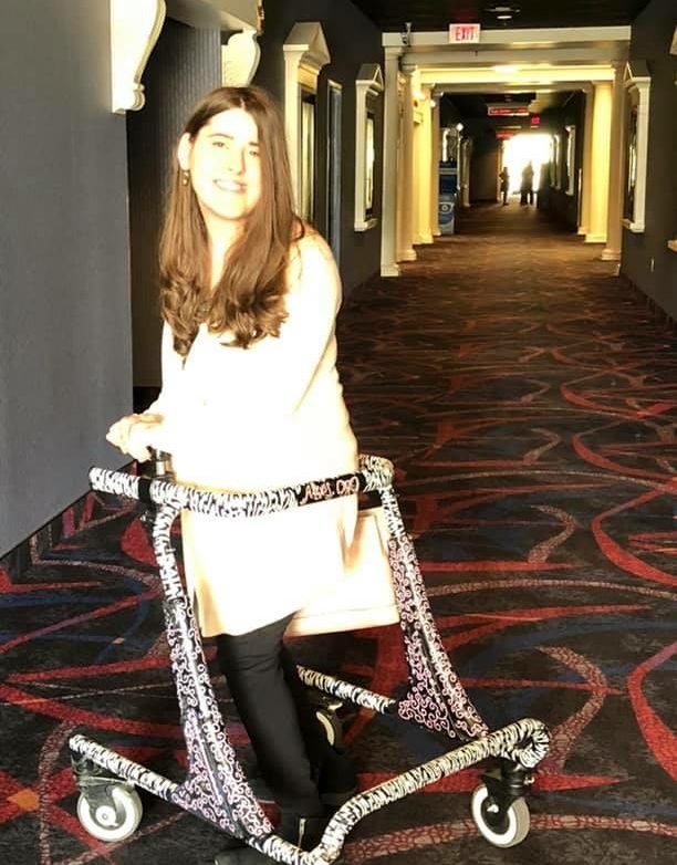 Alexis in her animal print walker in the movie theater.