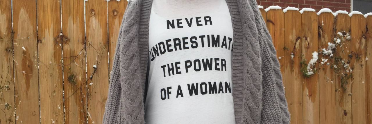 Developing Multiple Chronic Illnesses Tab wearing a shirt that says "Never underestimate the power of a woman."