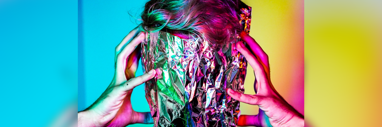 9 Surprising Physical Symptoms of Borderline Personality Disorder A person with their face wrapped in tinfoil dig their fingers into the side of their head. The bottom reads: 9 Surprising Physical Symptoms of Borderline Personality Disorder.